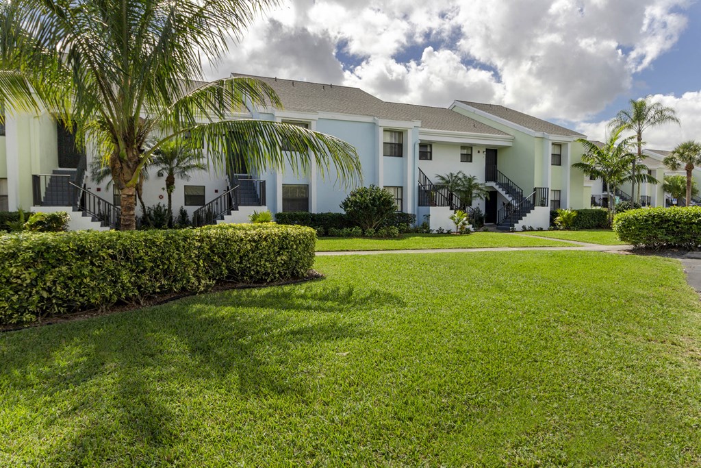 A row of houses with a green lawn in front.